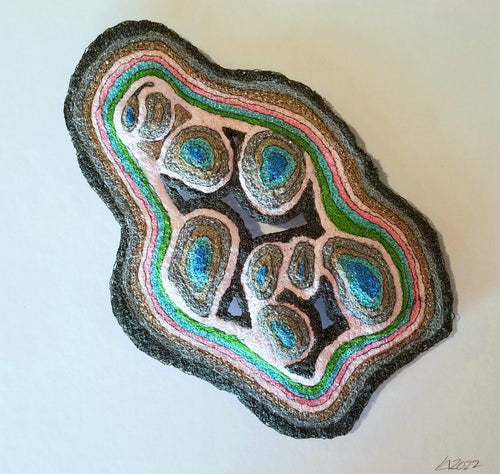 Agate-like rock with colorful concentric layers on a white background