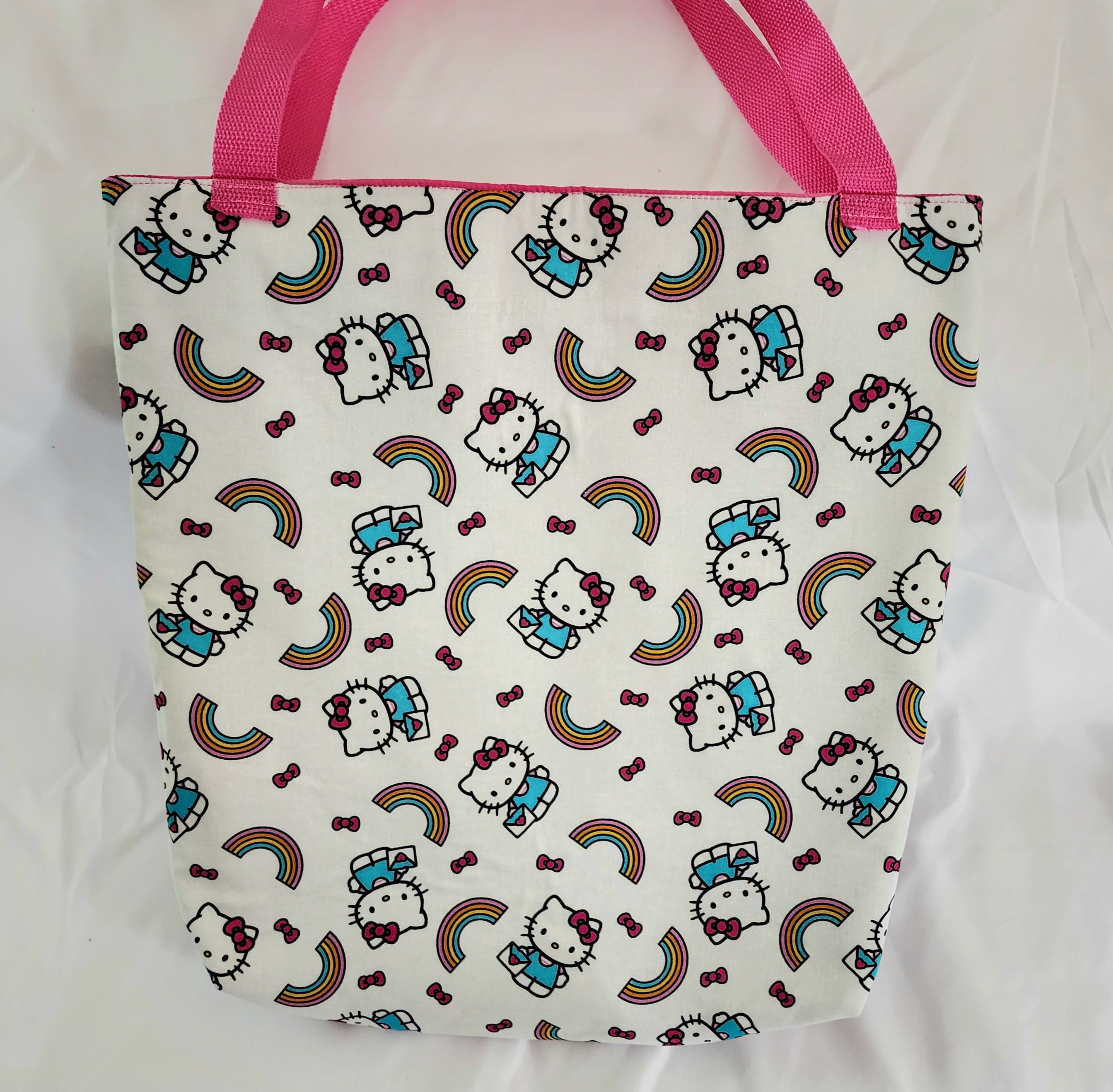 Tote bag with Hello Kitty pattern and pink handles on a white background