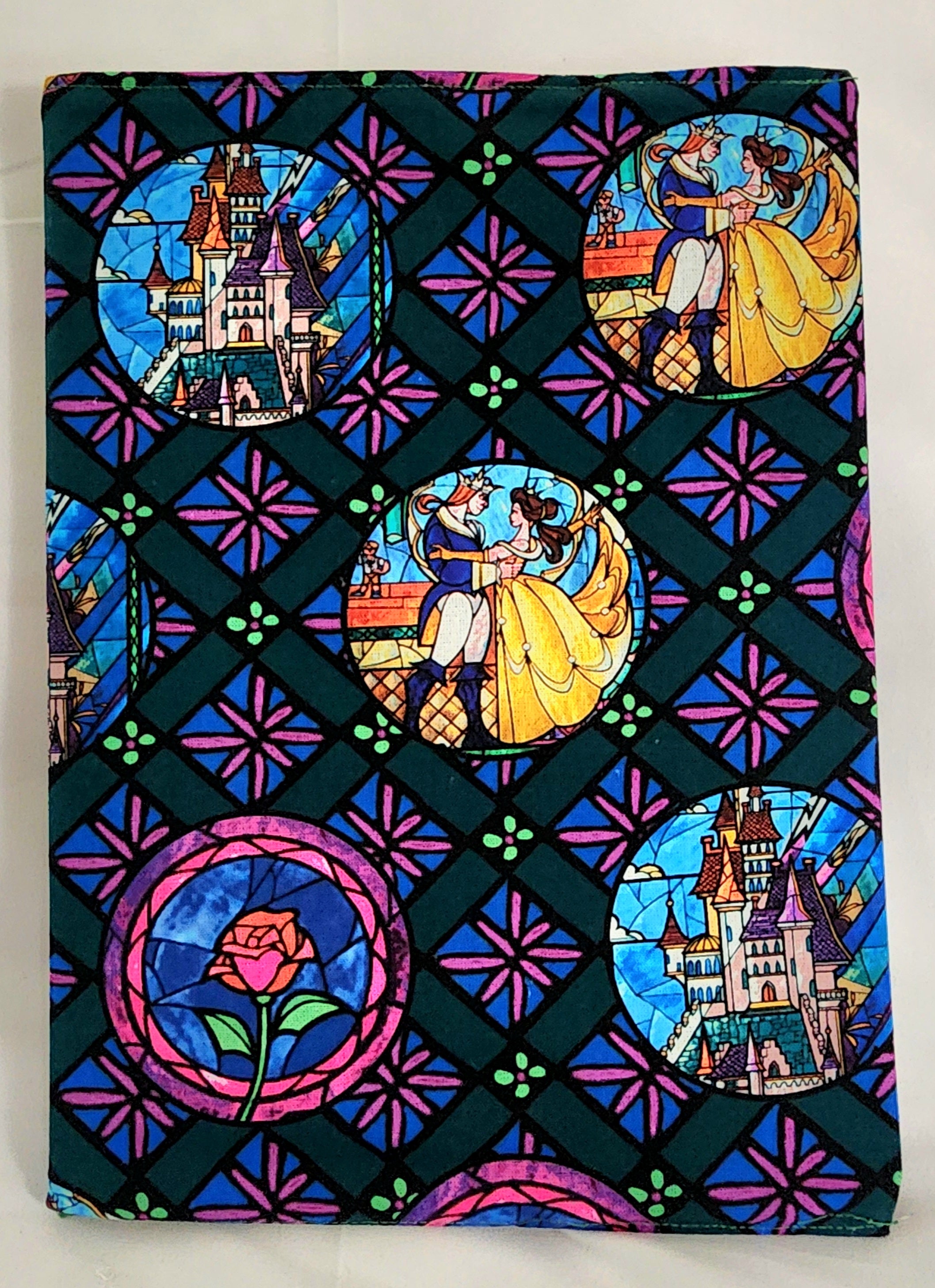 Stylized notebook cover with stained glass design featuring characters and castles.