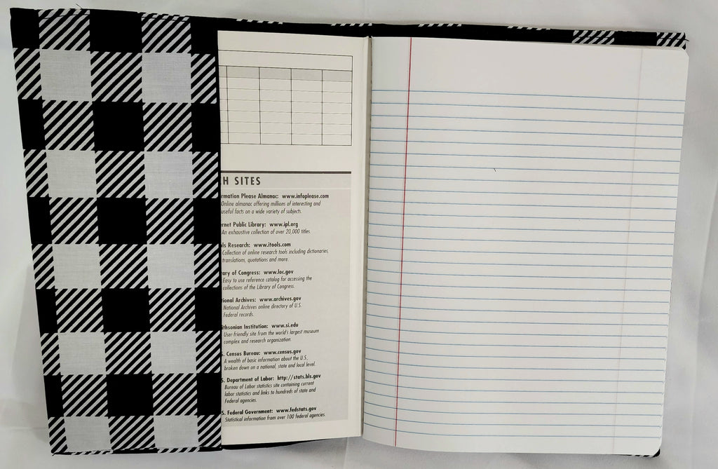 Open notebook with plaid cover and lined pages on a white background