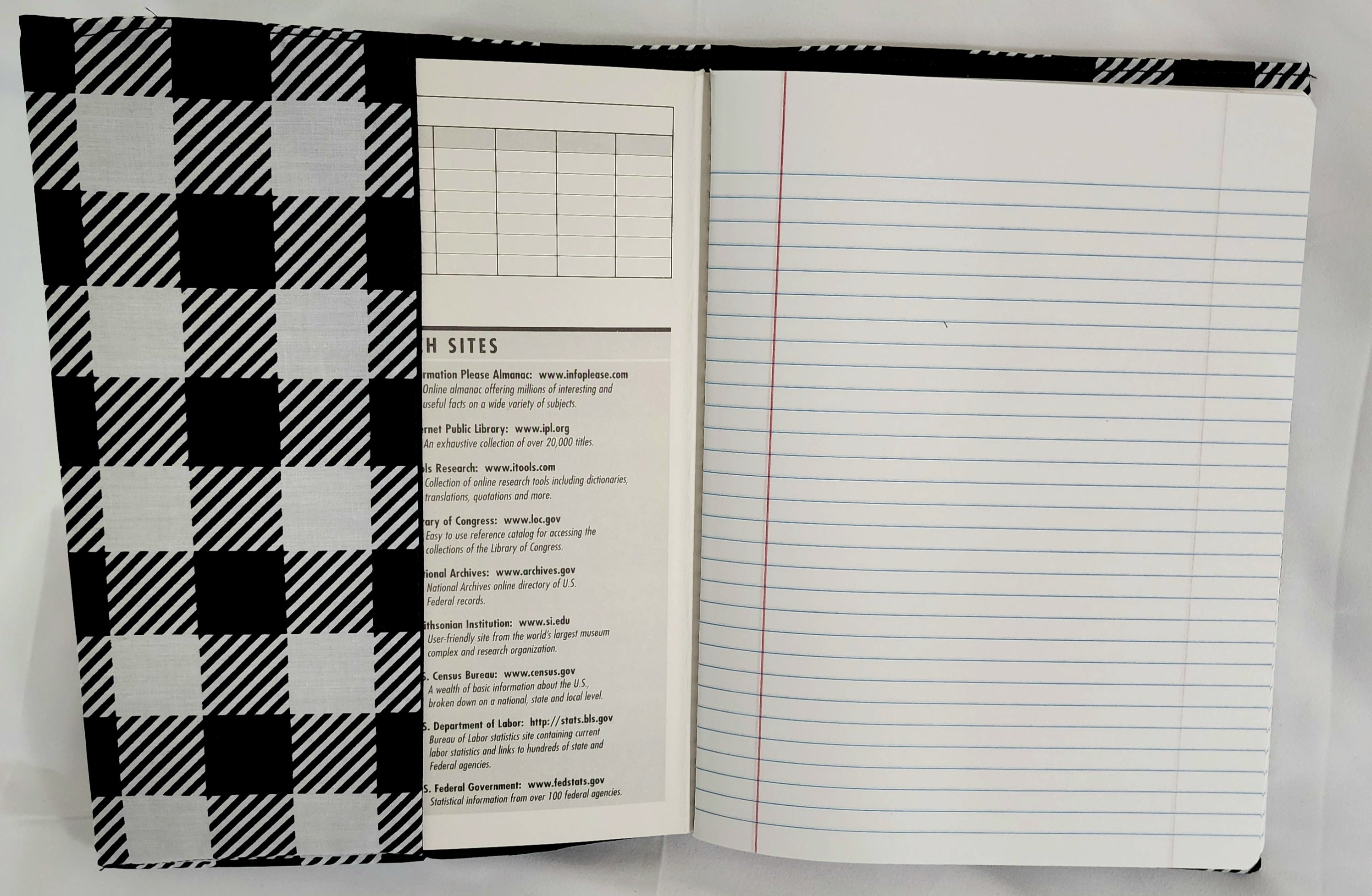 Open notebook with plaid cover and lined pages on a white background