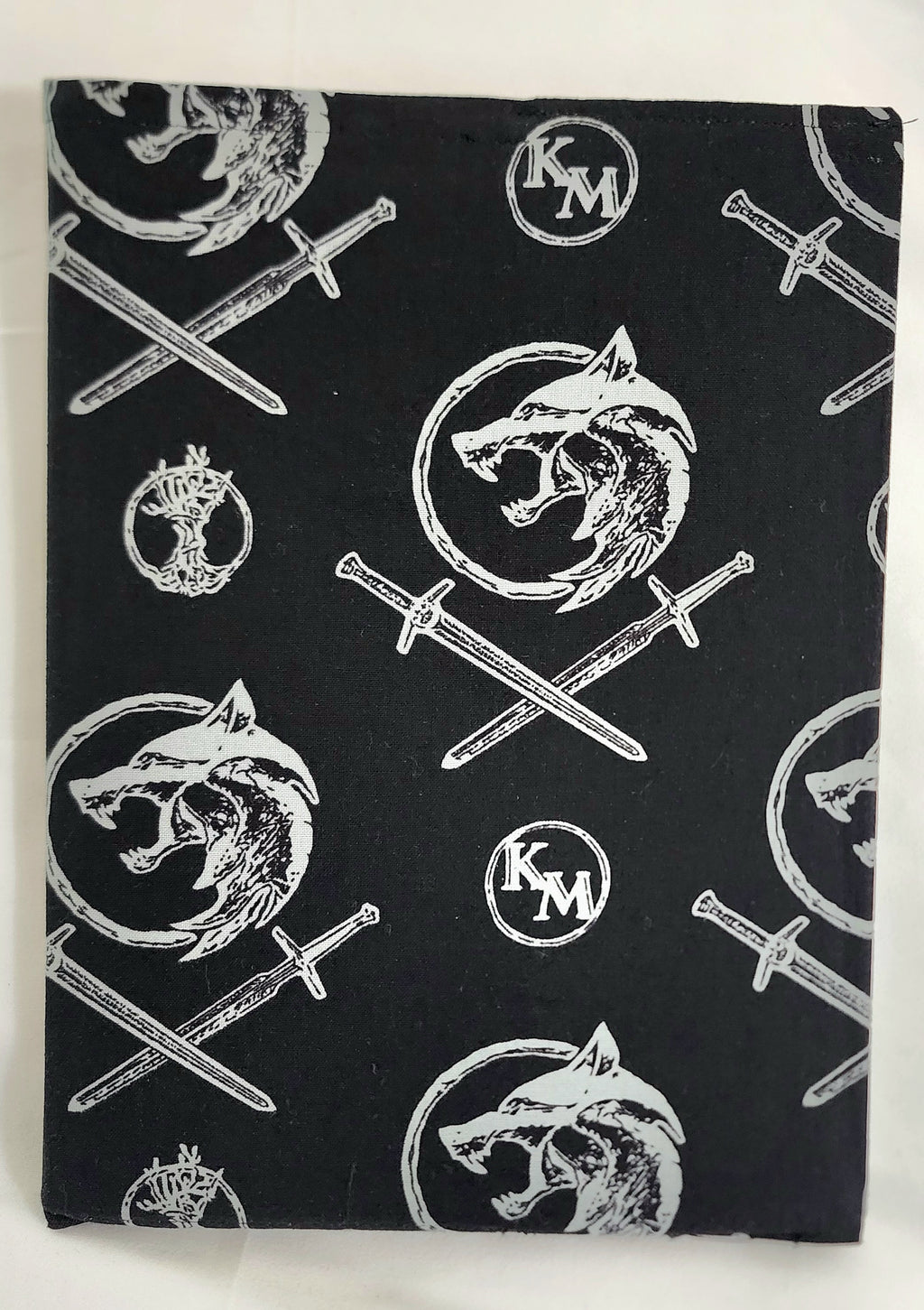 Black fabric with white wolf and sword pattern on a white background