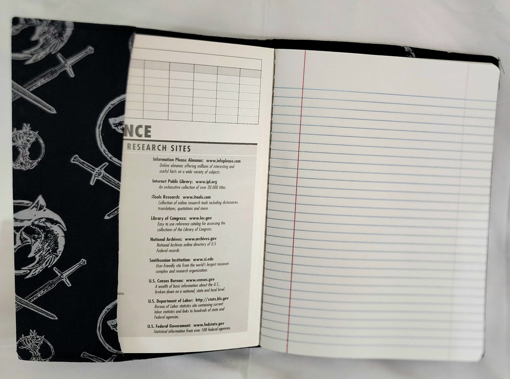 Open notebook with black cover featuring white designs on a white background