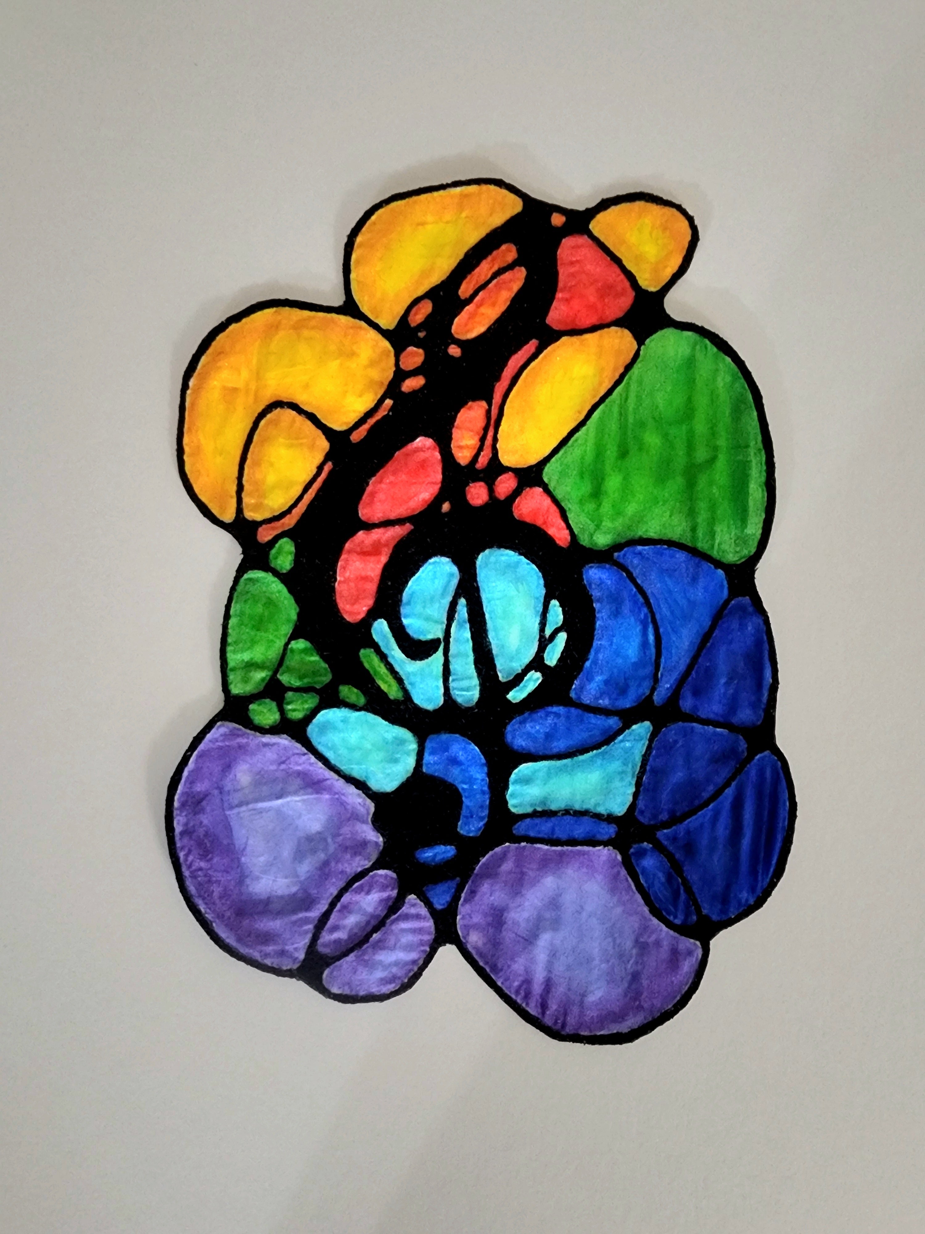 Colorful stained glass treble clef design on a plain background