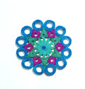 Mandala with blue circle ring, green, and pink circular patterns on a white background