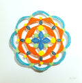Mandala circular design of orange  with blue center on a white background