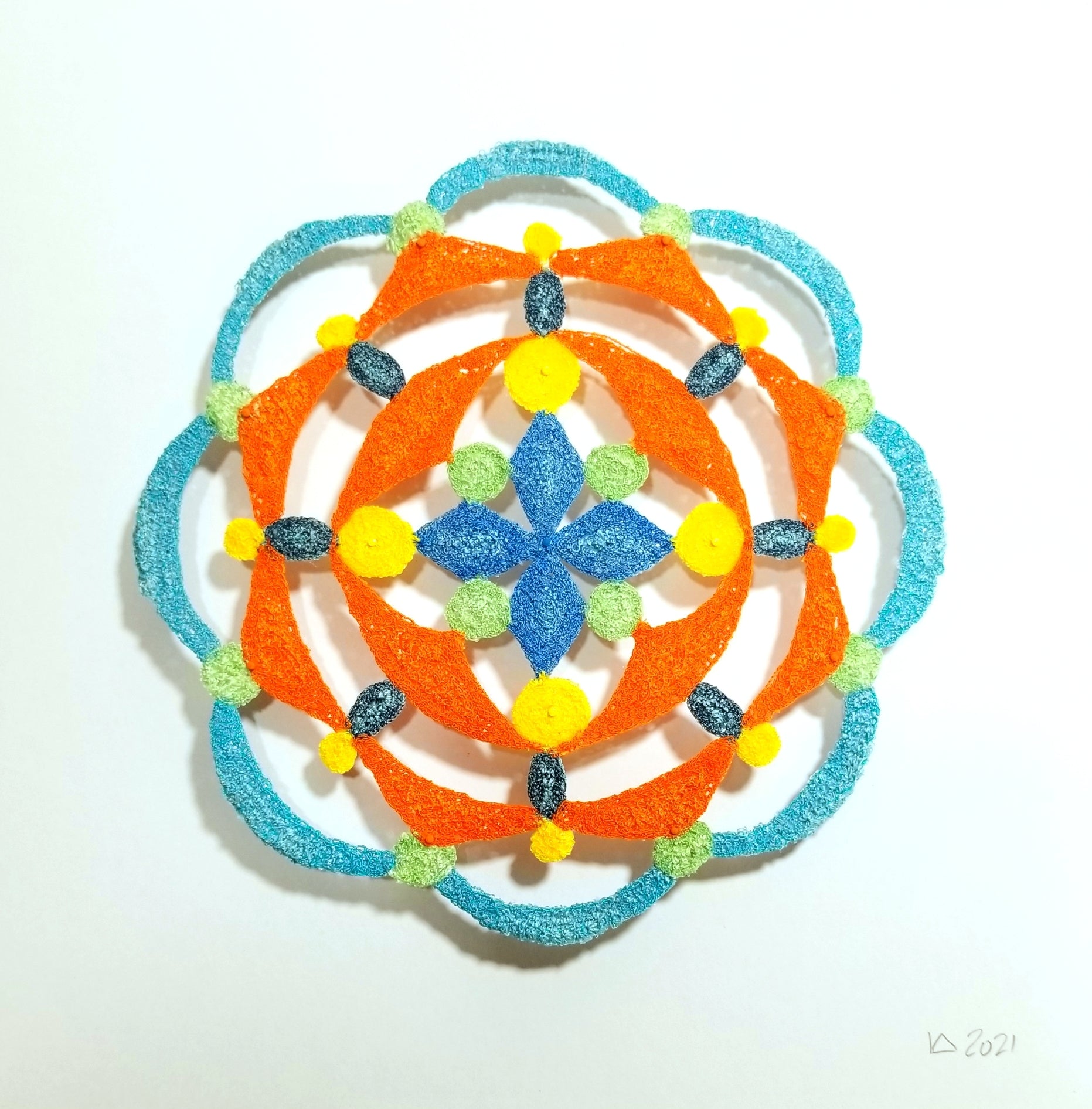 Mandala circular design of orange  with blue center on a white background