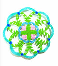 Mandala design with green leaves, pink flowers, and blue accents on a white background