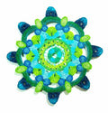 Decorative circular object with green and blue patterns on a white background