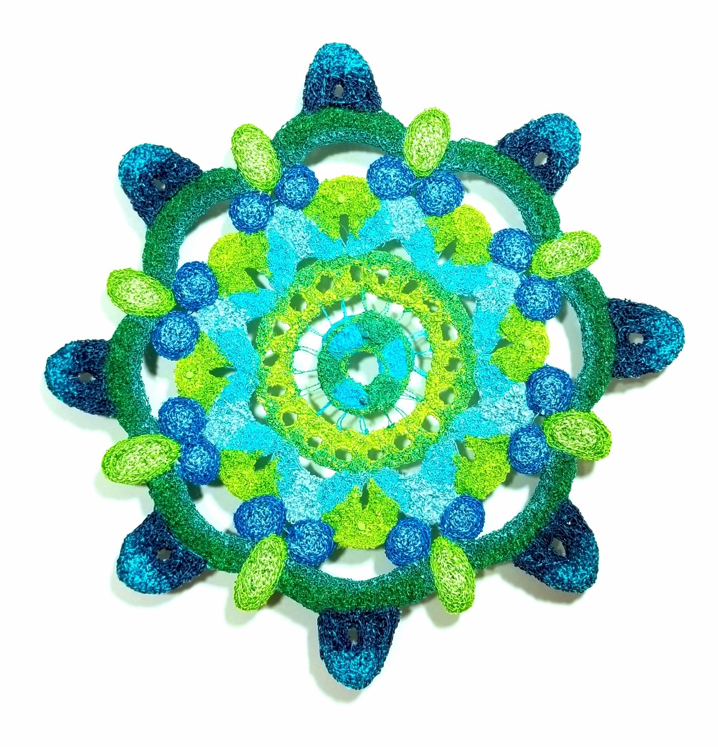 Decorative circular object with green and blue patterns on a white background