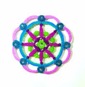 Mandala circular  with pink spokes, blue, green, and purple colors on a white background