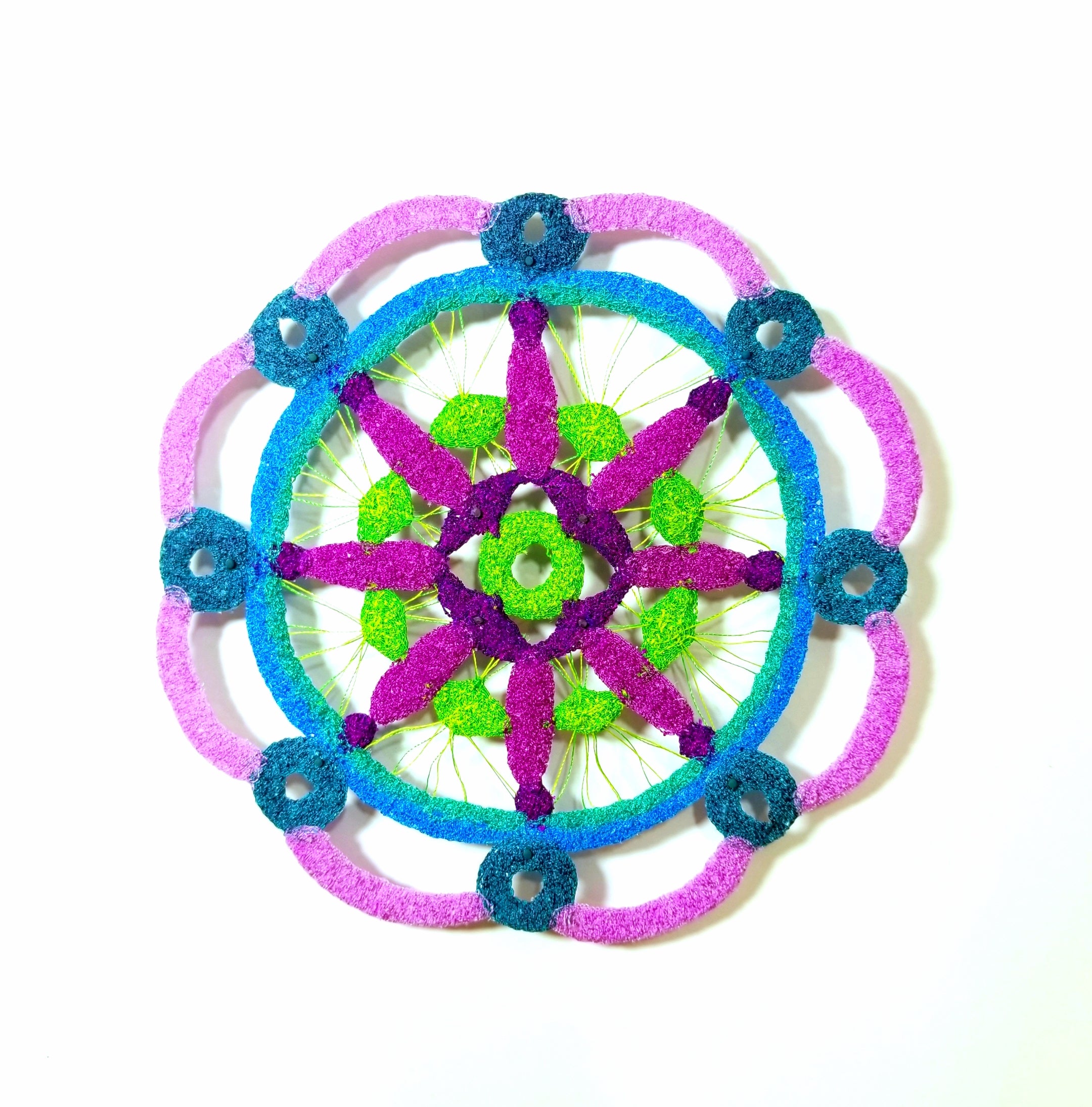 Mandala circular  with pink spokes, blue, green, and purple colors on a white background