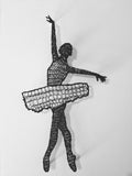 Black wire sculpture of a ballerina against a white background