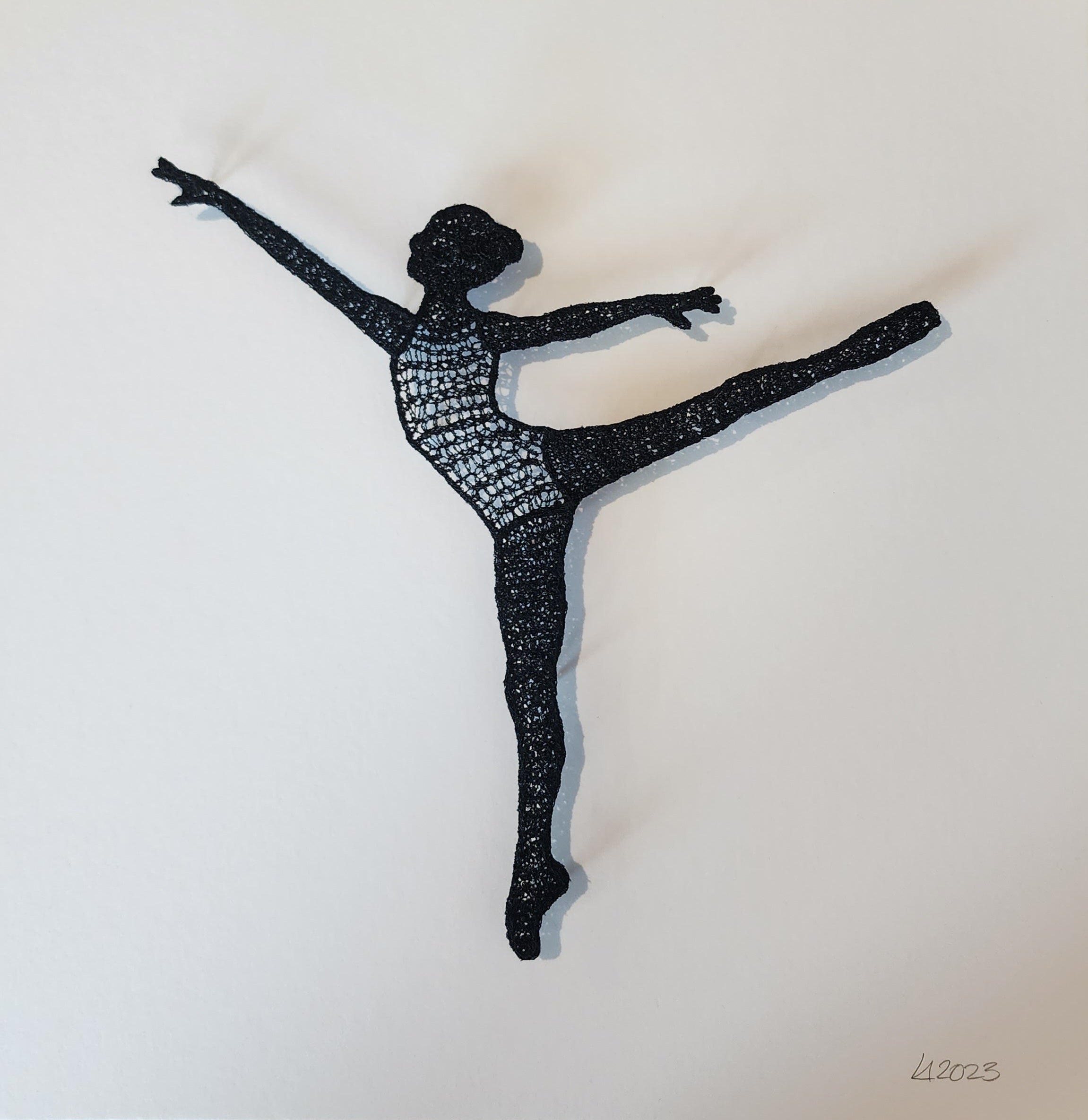 Black silhouette of a dancer in a dynamic pose on a white background