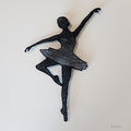 Black thread sculpture of a ballerina on white background