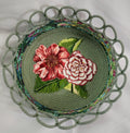 Decorative plate with floral design and green border on a white background