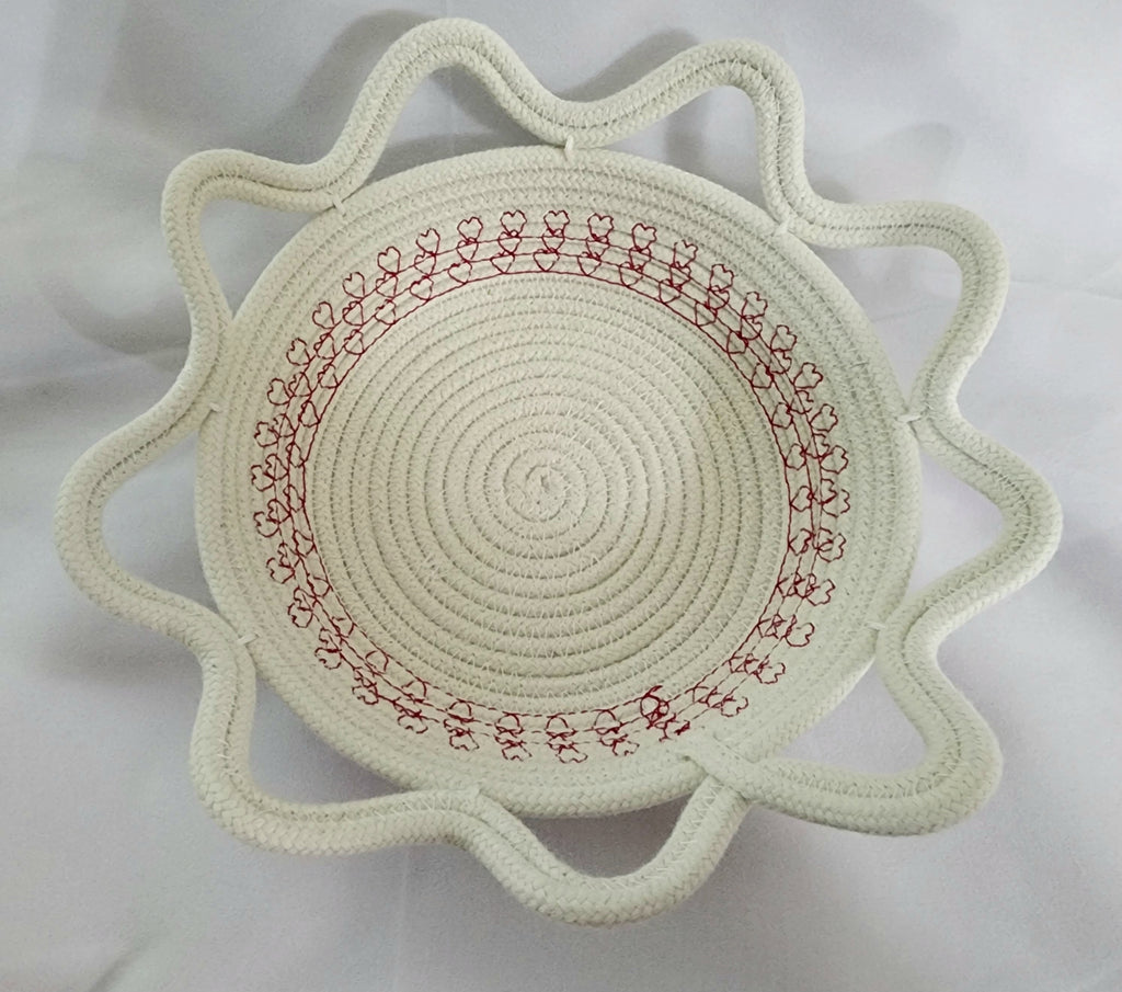Round woven bowl with red embroidery on a white background