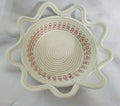 Round woven bowl with red embroidery on a white background