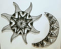 Decorative wall art of a sun and moon with intricate patterns on a white background