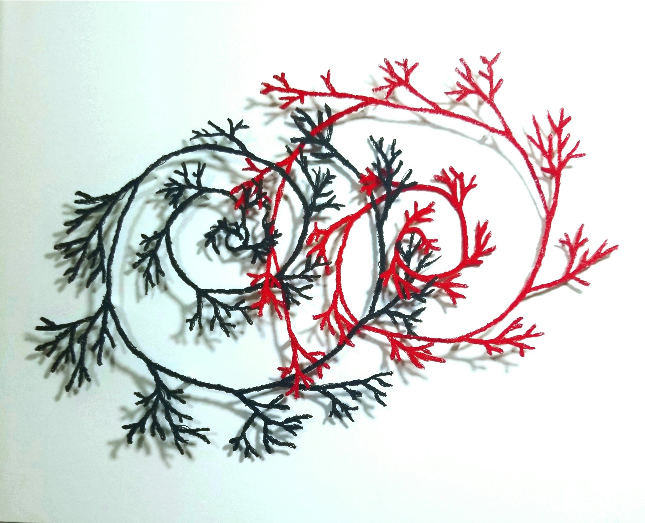 Artistic depiction of intertwined black and red branches on a white background