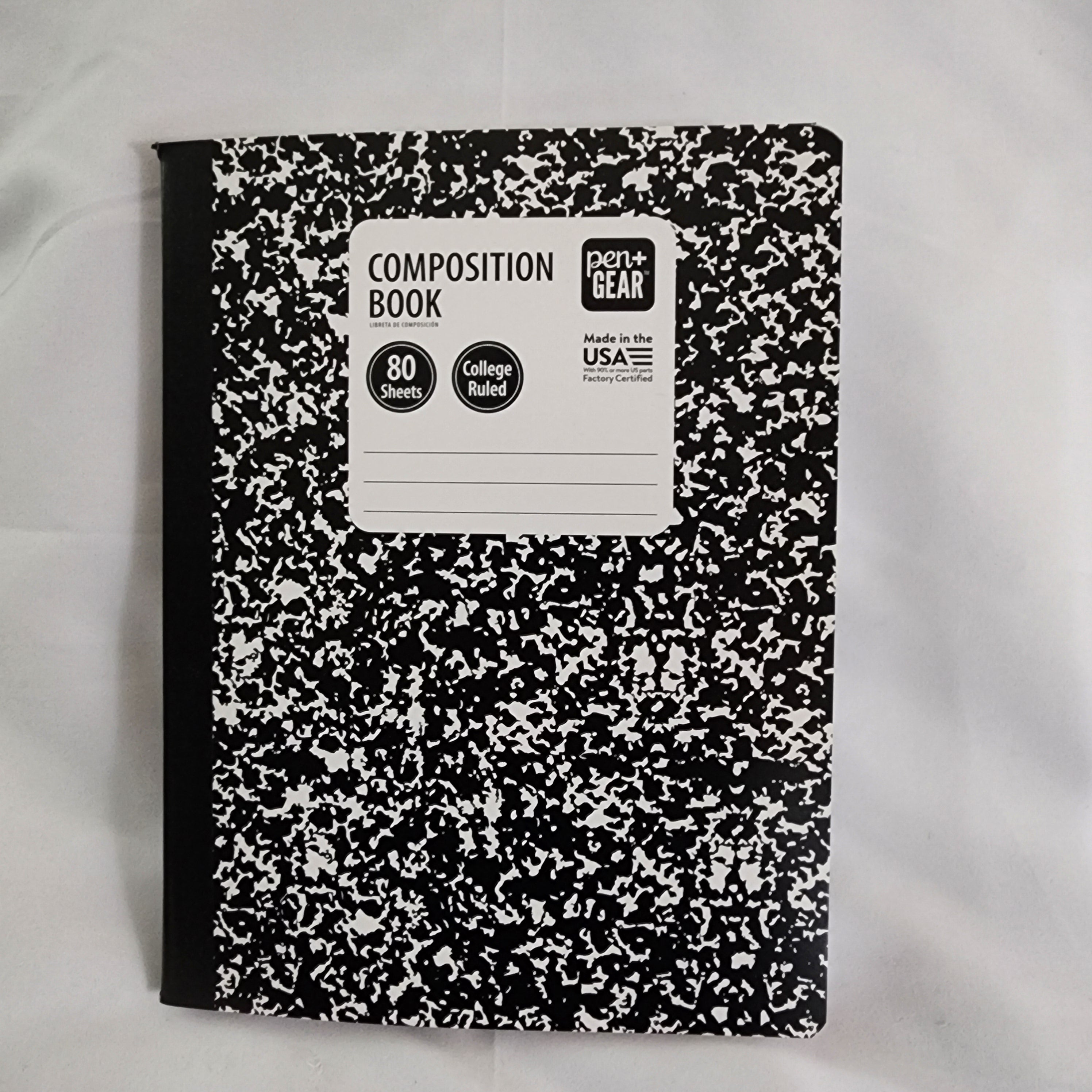 Composition book with black and white speckled cover on a light gray background